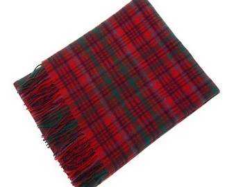 May include: A rectangular scarf with a red, green, and blue plaid pattern. The scarf has a fringed edge in matching colors. The scarf is made of a soft material and is suitable for cold weather.