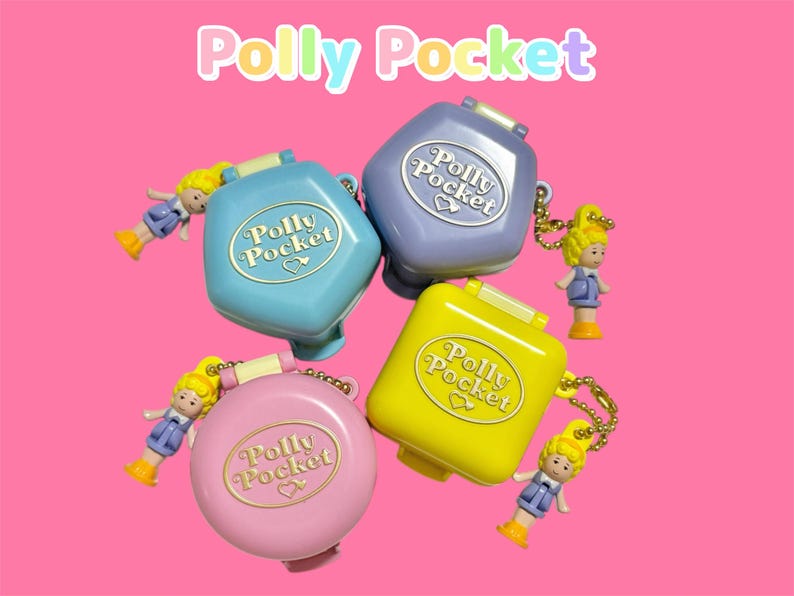 Może przedstawiać: Cztery zabytkowe kompakty Polly Pocket w kolorze niebieskim, fioletowym, ż&oacute;łtym i r&oacute;żowym, każdy z dołączoną miniaturową lalką. Logo Polly Pocket jest widoczne na każdym kompakcie na r&oacute;żowym tle.