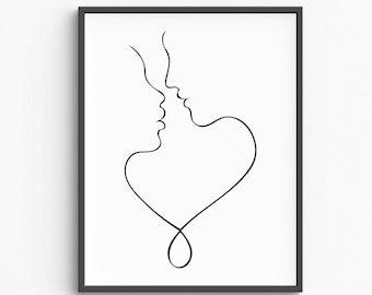 May include: Black framed wall art featuring a minimalist line drawing of two faces in profile, their lips nearly touching, with a heart shape formed by a continuous line. The artwork is set against a white background.
