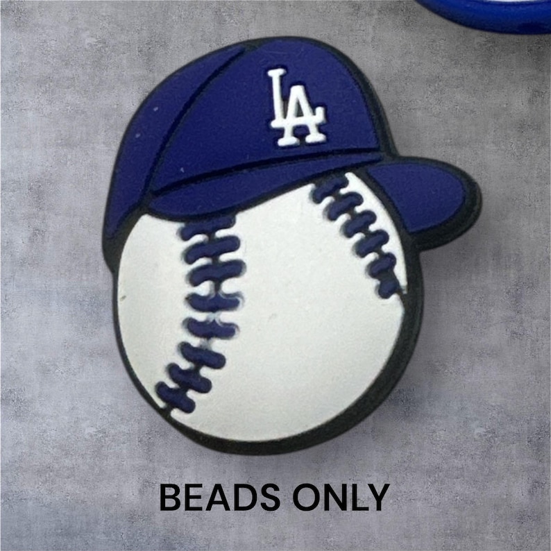 May include: A baseball-themed bead featuring a blue baseball cap with the white letters "LA" and a white baseball with black stitching. The text "BEADS ONLY" is at the bottom.