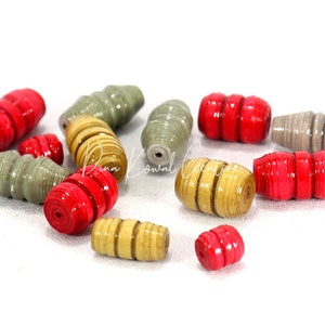May include: Assortment of colorful paper beads in red, beige, and gray. The beads are rolled and have a textured appearance.