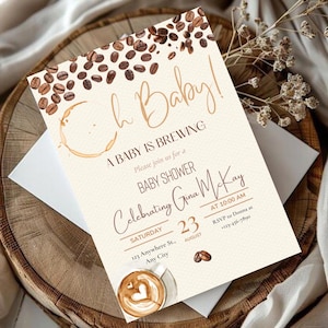 Pode incluir: Convite para chá de bebé com tema de café. O convite apresenta o texto "Oh Baby! A Baby is Brewing" com gráficos de grãos de café e manchas de café. Os detalhes incluem a data, hora e informações de RSVP.