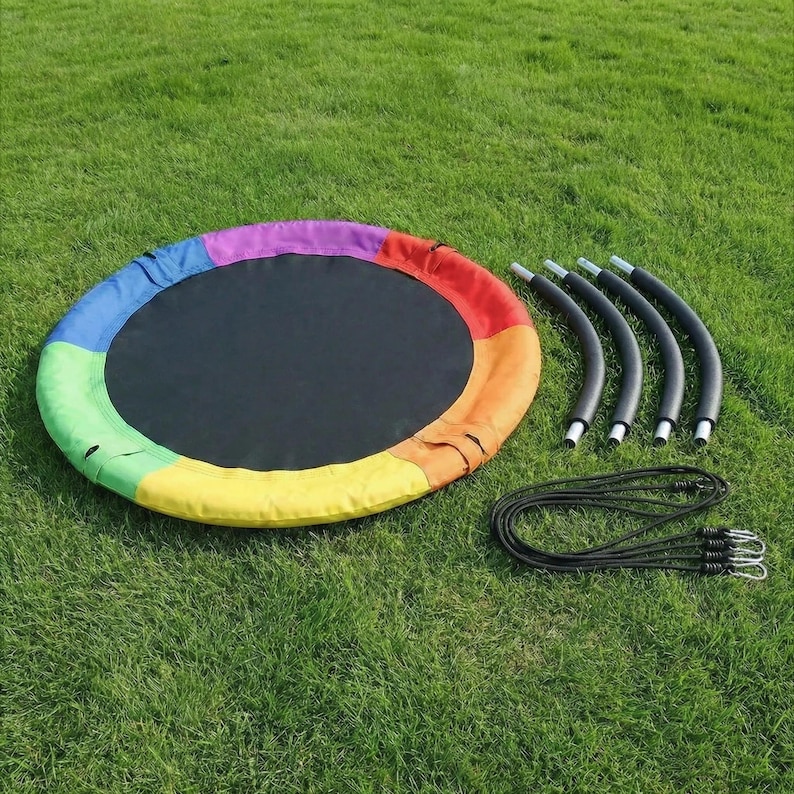 May include: A round, rainbow-colored swing seat with a black center. The swing has a colorful fabric border and comes with curved metal support bars and black rope with metal hooks. The swing is shown on a green grassy surface.