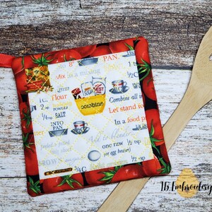 May include: Red and black pot holder with a recipe printed on it. The recipe includes ingredients like flour, sugar, and salt. The pot holder has a loop handle and is decorated with tomatoes.