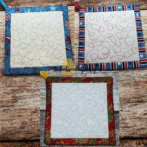 May include: Three quilted pot holders with different designs. One has a blue border with stars and stripes, and a white center with star patterns. Another has a red, white, and blue border with a white center and rocket patterns. The third has a red and green border with a white center and holly patterns.
