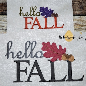 May include: Embroidered design featuring the text "hello fall" in gray and orange with a red and brown leaf and acorns. The design is on a white fabric background.