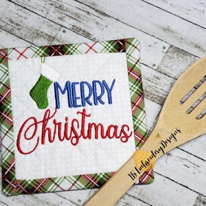 May include: A red and green plaid pot holder with the words "Merry Christmas" embroidered in red and blue. A small green stocking with a blue cuff is embroidered in the upper left corner.
