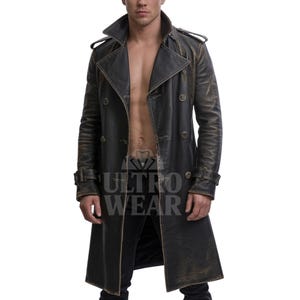 Könnte beinhalten: Ein schwarzer Trenchcoat aus Leder mit Used-Look und doppelreihigem Design. Der Mantel hat einen Reverskragen, Schulterklappen und ein Gürteldetail an den Manschetten. Der Mantel hat ein Vintage-Aussehen mit goldenen Akzenten.
