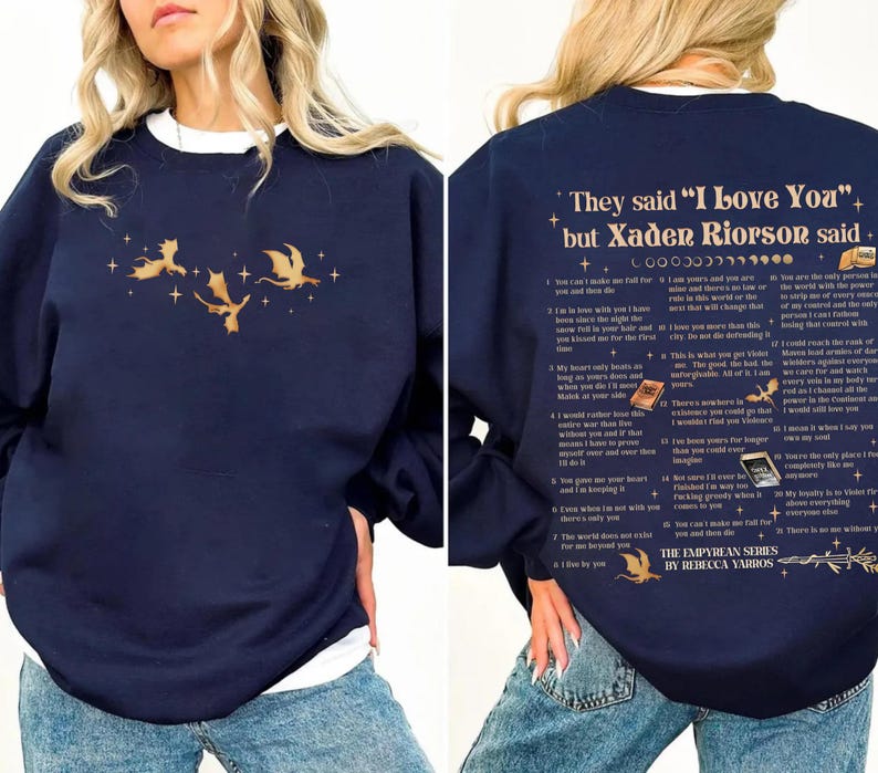 May include: Navy blue sweatshirt with a white crew neck collar. The front features a gold dragon graphic. The back of the sweatshirt has text that reads "They said 'I Love You' but Xaden Riorson said..." and a list of quotes.