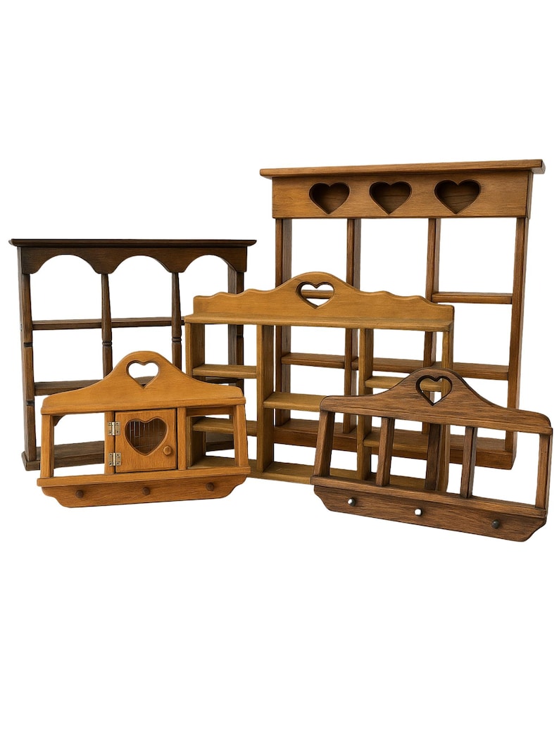 May include: A collection of five wooden wall shelves in various brown tones. Each shelf features heart-shaped cutouts, open storage compartments, and some include small doors or hooks. The shelves vary in size and structural design, showcasing natural wood grain textures and smooth finishes throughout the set.