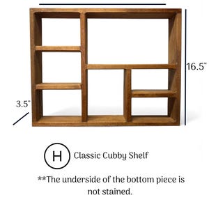 May include: A brown wooden cubby shelf with multiple compartments. The shelf measures 21 inches wide, 16.5 inches high, and 3.5 inches deep. Text on the image reads: H Classic Cubby Shelf, and The underside of the bottom piece is not stained.