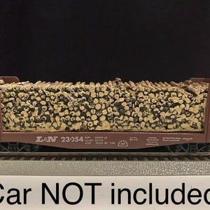May include: A brown model train car with a load of stacked logs. The car is labeled "L&N 23954".