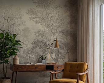 May include: A home office setup featuring a wooden desk with drawers, a mustard-colored armchair, and a potted plant. The wall is adorned with a black and white forest-themed wallpaper, and a gold desk lamp sits on the desk.
