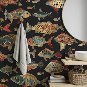 Könnte beinhalten: Schwarze Tapete mit einem sich wiederholenden Muster aus farbenfrohen, stilisierten Fischen. Die Fische sind in Orange-, Gelb-, Blau- und Grüntönen gehalten und weisen komplizierte Details auf. Ein weißes Handtuch hängt an Messinghaken, und ein weißes Waschbecken ist sichtbar.