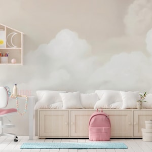 Peut inclure: Chambre d'enfant lumineuse avec une murale de nuages. Comprend un sac à dos rose, un bureau blanc avec une chaise rose et un banc de rangement en bois avec des coussins blancs. Une étagère décorative en forme de maison est fixée au mur.