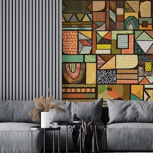 May include: A contemporary living room with a grey sectional sofa, cushions, a small black side table, and a decorative cactus in a black pot. The wall behind the sofa has a geometric design with various colours.