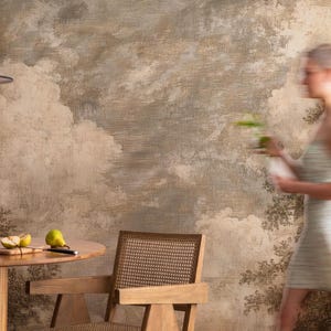 May include: A dining room scene featuring a round wooden table with pears and a knife on a cutting board. A decorative vase and a wooden chair are also visible. The background is a mural with a cloudy landscape.