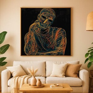 May include: Abstract artwork depicting a figure outlined in orange and teal lines on a black backdrop, framed in gold. The artwork hangs above a beige sofa with cushions. The room is decorated in neutral tones, creating a calming atmosphere.