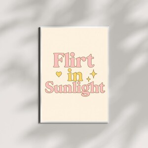 Puede incluir: Una impresión de arte de pared imprimible rosa y amarilla con el texto "Flirt in Sunlight" con un corazón y estrellas.