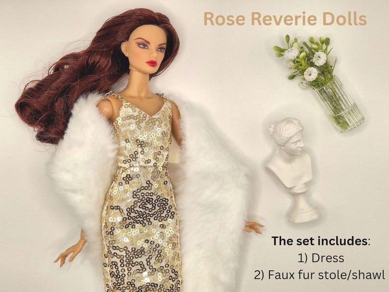 May include: A doll wearing a gold sequined dress and a white faux fur stole. The image includes a small white bust, a vase of flowers, and the text "Rose Reverie Dolls". The set includes a dress and a faux fur stole/shawl.