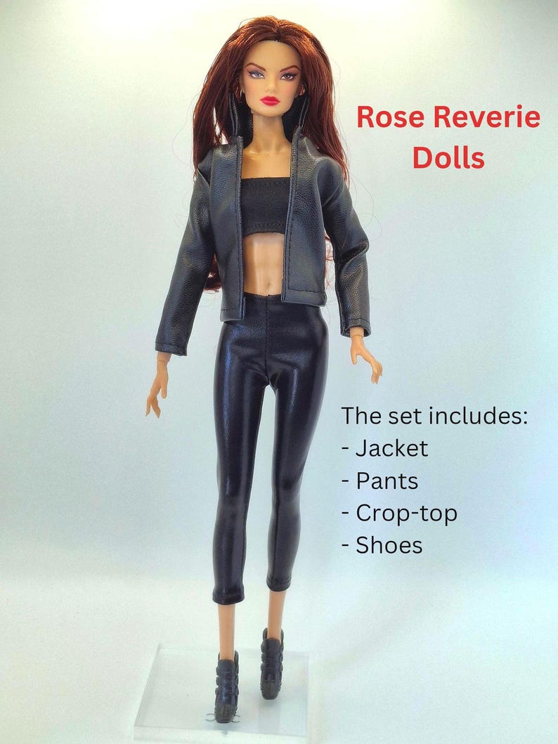 May include: A fashion doll wearing a black jacket, crop top, and pants. The doll has long auburn hair and is wearing black shoes. The text "Rose Reverie Dolls" is visible. The set includes a jacket, pants, crop-top, and shoes.