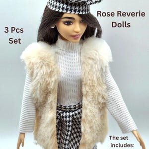 May include: A doll wearing a white sweater, a faux fur vest, and a black and white houndstooth skirt and beret. The set includes a dress, vest, and hat. The text on the image says "Rose Reverie Dolls" and "3 Pcs Set".