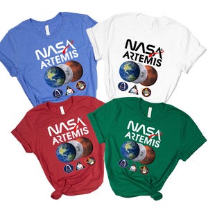 May include: Four short-sleeved t-shirts in blue, white, red, and green. Each shirt displays the NASA Artemis logo, with Earth, Moon, and Mars imagery. The NASA logo and Artemis text are in white.