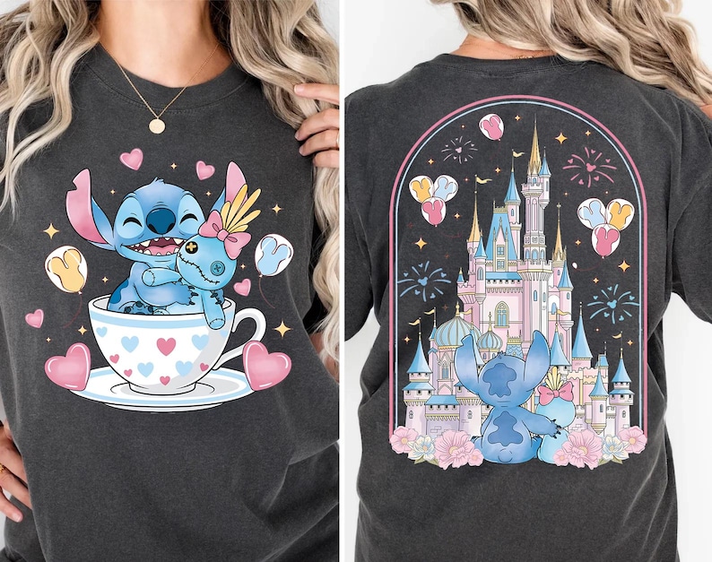 Puede incluir: Camiseta gris oscuro con un dibujo animado de Stitch y una mu&ntilde;eca en una taza de t&eacute; con corazones. La parte trasera de la camiseta muestra a Stitch y la mu&ntilde;eca frente a un castillo con fuegos artificiales y globos. El dise&ntilde;o es en tonos azules, rosas y amarillos.