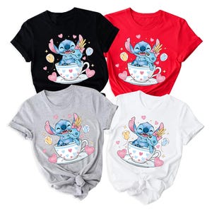 Puede incluir: Cuatro camisetas de manga corta en negro, rojo, gris y blanco. Cada camiseta presenta un gr&aacute;fico de dibujos animados de un personaje alien&iacute;gena azul en una taza de t&eacute; con corazones y globos. Las camisetas est&aacute;n anudadas a la cintura.