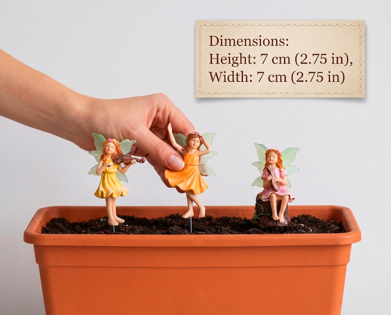 May include: Three fairy figurines with translucent wings, each wearing a floral crown and a dress in yellow, orange, or pink. The figurines are mounted on stakes and measure 2.75 inches in height and 2.75 inches in width, as shown in the text.