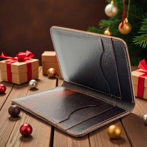 May include: Open brown leather wallet with card slots, displaying a rich, textured finish. The wallet is open, revealing interior pockets and a dark interior. The background features Christmas decorations and wrapped gifts, suggesting a festive theme.