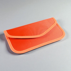 May include: Bright orange clutch with a textured surface and a curved flap closure. The edges are trimmed with a lighter orange color. The clutch is rectangular and appears to be made of a durable material.