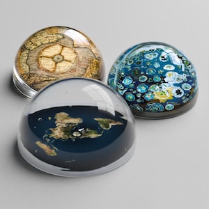 Puede incluir: Un juego de tres tazas de cerámica con un acabado moteado y mate. Las tazas son de color crema, gris claro y gris oscuro. Cada taza tiene un diseño simple y minimalista.