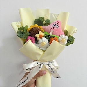 May include: A bouquet featuring a plush Patrick Star, crocheted flowers, and greenery, wrapped in pale yellow paper. The bouquet is tied with a white ribbon printed with "Just for you".