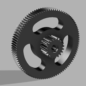 May include: A black gear set with a large outer gear and a smaller inner gear. The large gear has three curved cutouts and many teeth around the outer edge. The smaller gear is centered inside the larger gear.