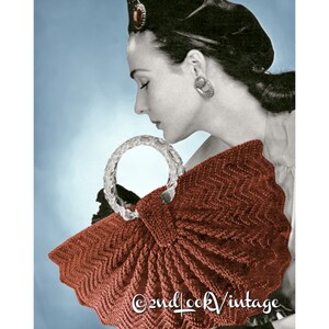 Peut inclure: Un sac &agrave; main vintage en crochet avec un motif chevron brun et une poign&eacute;e en plastique transparent. Le sac est en forme de demi-cercle et a un bord festonn&eacute;. L'image comprend le texte "&copy;2ndlookvintage".