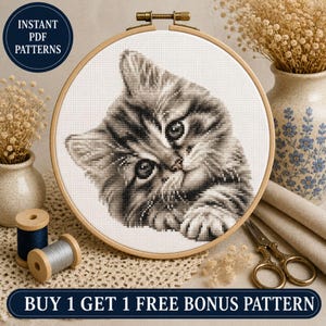 Può includere: Un telaio da ricamo circolare in legno contenente un motivo a punto croce di un gattino tigrato grigio. Il gattino è raffigurato in tonalità di grigio e bianco, rivolto verso l'alto. Il testo INSTANT PDF PATTERNS e BUY 1 GET 1 FREE BONUS PATTERN è visibile.