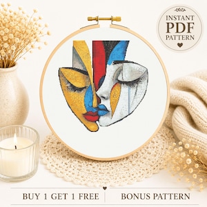 May include: A cross stitch pattern in a wooden embroidery hoop featuring an abstract design of two faces in yellow, red, blue, and white. The design includes text that reads INSTANT PDF PATTERN and BUY 1 GET 1 FREE BONUS PATTERN.