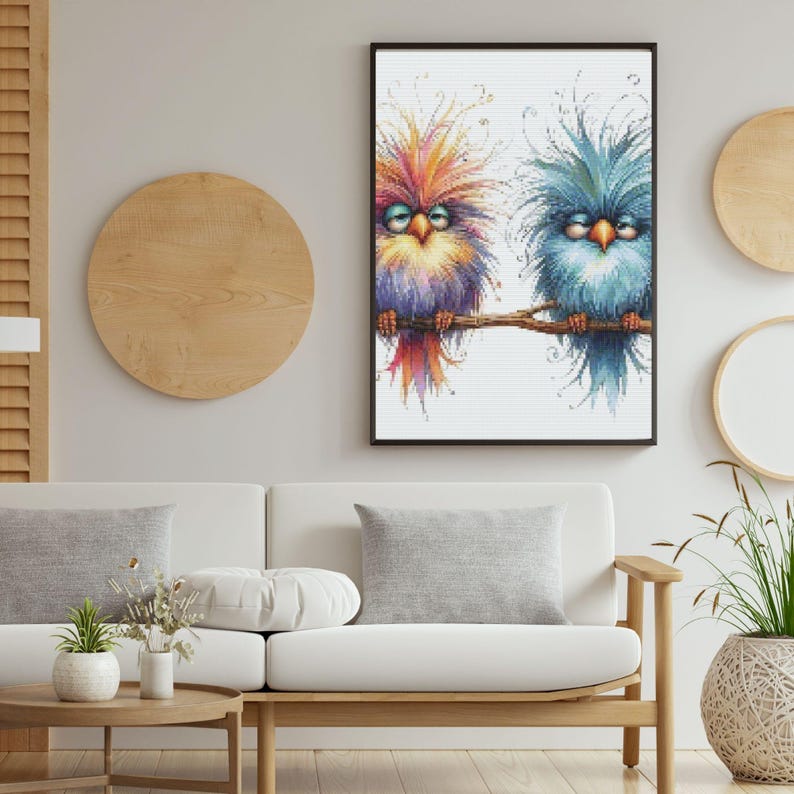 K&ouml;nnte beinhalten: Ein gerahmtes Kunstwerk mit zwei skurrilen V&ouml;geln auf einem Ast. Die V&ouml;gel haben farbenfrohes, strukturiertes Gefieder in Orange, Lila und Blau. Das Kunstwerk wird &uuml;ber einem wei&szlig;en Sofa in einem Wohnzimmer gezeigt.