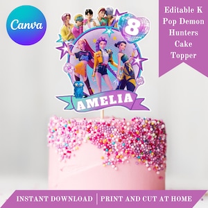 May include: A pink cake with colorful sprinkles, topped with a cake topper featuring a group of animated characters. The topper includes the name "AMELIA" and the text "Editable K Pop Demon Hunters Cake Topper". The Canva logo is visible.