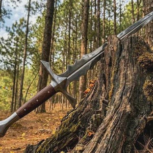May include: A detailed, silver-colored sword with a wooden handle, resting on a tree stump in a forest. The blade has a unique, serrated design. The handle is a dark brown color with silver accents.