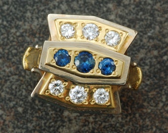 Art deco inspired sapphire and diamond ring set in 18 karat yellow gold and 14 karat white gold.  Stunning!