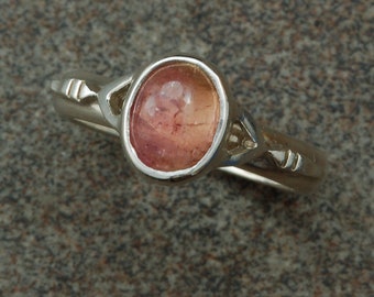 Sterling silver ring set with oval pink tourmaline cabochon.