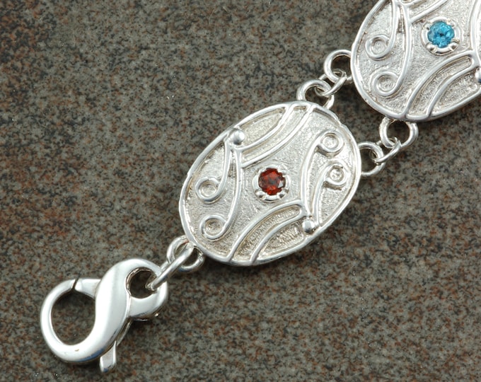 Sterling silver antique style link bracelet with multiple gemstones.