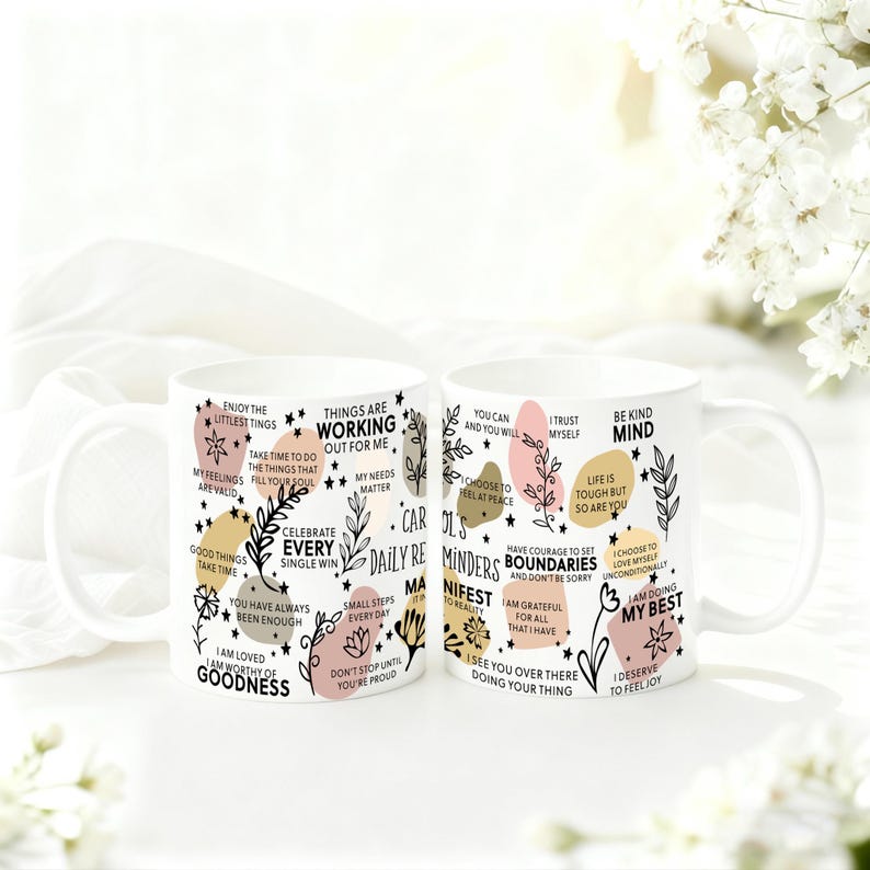 May include: Two white ceramic mugs with inspirational quotes and floral designs. The mugs feature phrases like "Things are working out for me" and "I am doing my best" in a mix of fonts and colors.