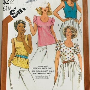 May include: Vintage Simplicity sewing pattern for one-yard tops. The pattern envelope features illustrations of four different top designs, including a yellow top, a pink top, a blue top, and a white top with a star pattern. The size is 10.