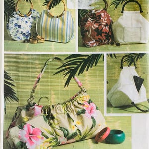 May include: Collection of handbags with various designs. Includes a blue floral print bag, a striped bag, a bag with a tropical leaf pattern, and a white bag with a pocket. The bags have bamboo handles and straps.