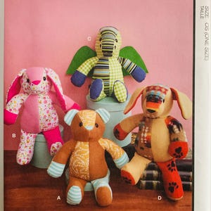 May include: McCall's M8470 sewing pattern envelope featuring four stuffed animals: a pink floral rabbit, a brown bear with patterned patches, a green winged creature with striped and checkered fabric, and a tan dog with paw print accents.