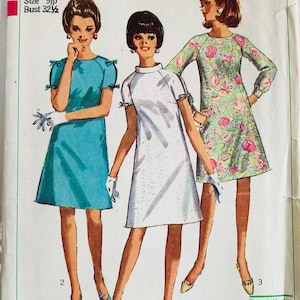 May include: Simplicity sewing pattern 7034 for junior petites. The pattern features three dresses: a turquoise dress, a white dress, and a floral print dress. The pattern includes the text "Jr. Petite Size 9jp Bust 32 1/2".
