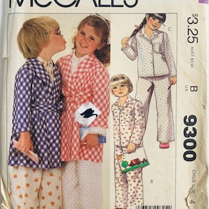 May include: Vintage McCall's sewing pattern for children's pajamas. The pattern features illustrations of children in various pajama sets and robes. The pattern number is 9300, and the size is child size 4. The cover is a pastel color.